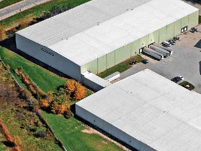 Top view of two connected commercial warehouses with white, slightly slanted roofs