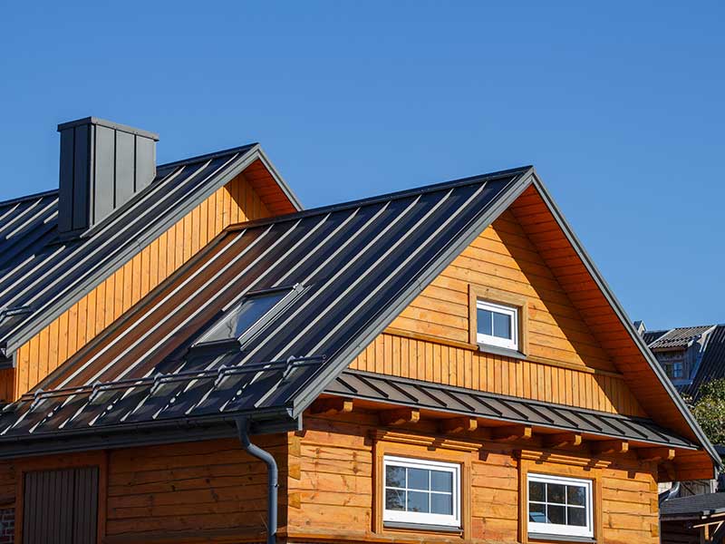 Home with a wooden aesthetic exterior and a black metal roof